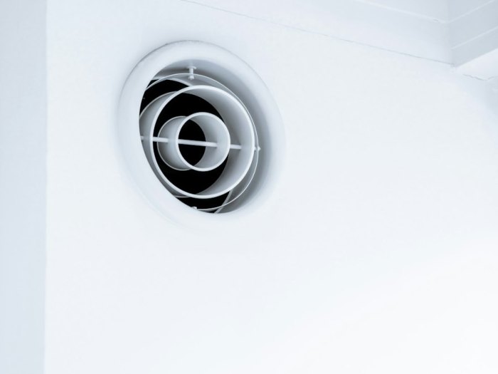 Bouche de ventilation ronde sur un mur blanc